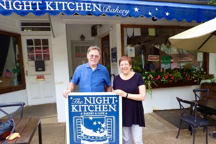 John Millard and Amy Beth Edelman, owners of Night Kitchen Bakery in Chestnut Hill, stand in front of their business in 2025.