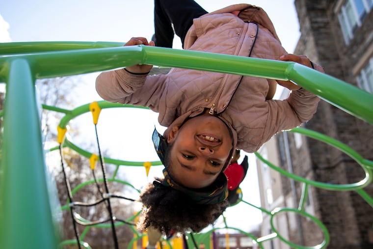 Samya Demercado, 7, a second grader at Overbrook Education Center, plays on the monkey bars on the new playground. The Philadelphia School District elementary school, which educates the city's blind and visually impaired children as well as regular education students, had no playground until this year.