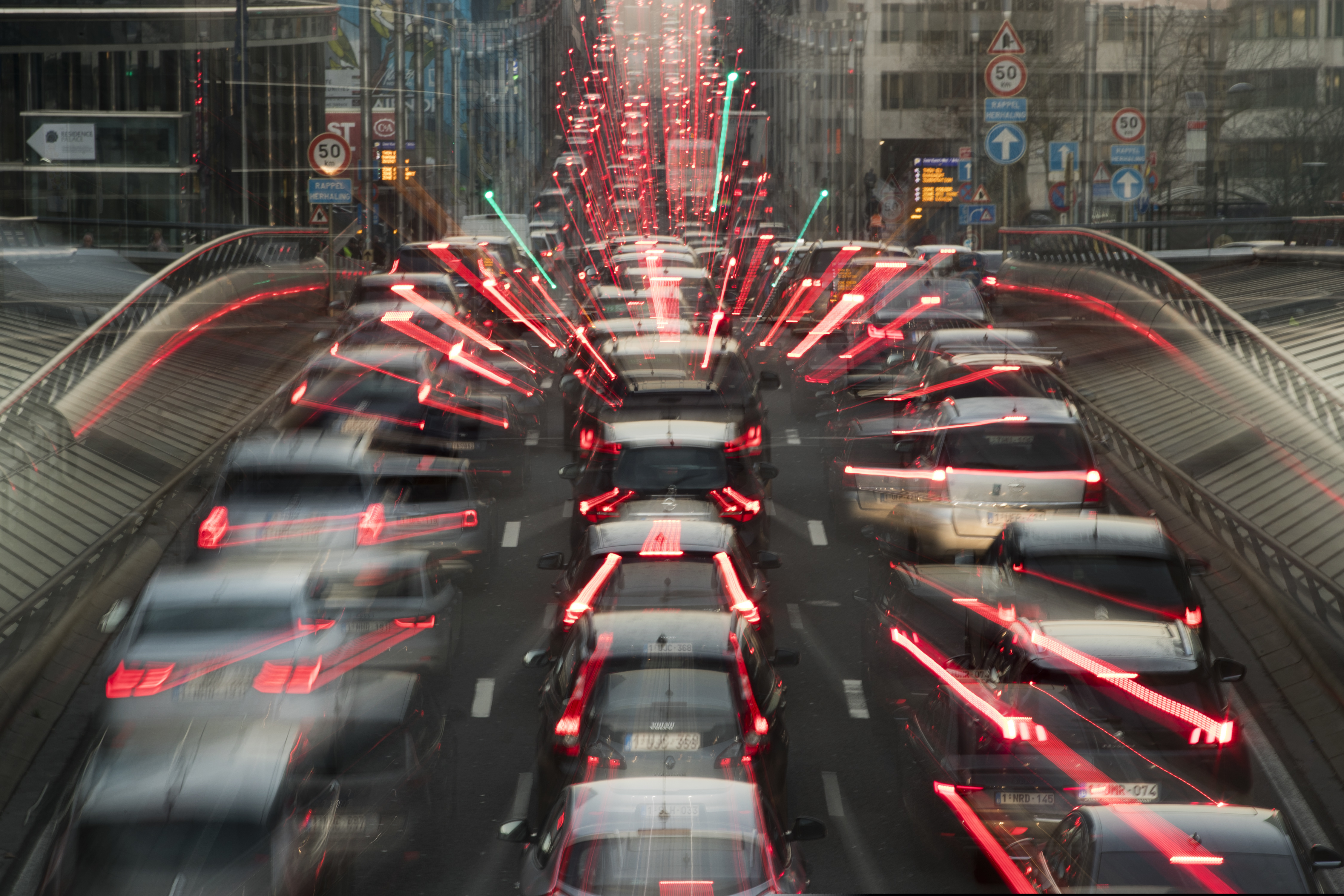 In this slow-shutter zoom effect photo, commuters backed up in traffic during the morning rush hour Wednesday, Dec. 12, 2018, in Brussels, a city that regularly experiences pollution alert warnings. Predictions from international climate expert, warn that global warming is set to do irreversible environmental damage, with pollutants from burning fossil fuels as one of the main contributors to climate changes. (AP Photo/Francisco Seco)