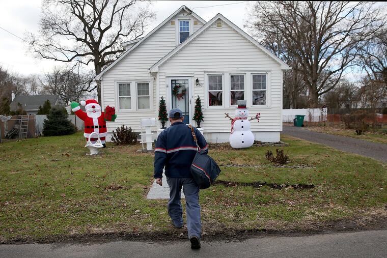 A letter carrier delivers mail in Croydon, Bucks County, in this December 2018 file photo. This year, more consumers are feeling generous and plan to give small gifts to service workers.