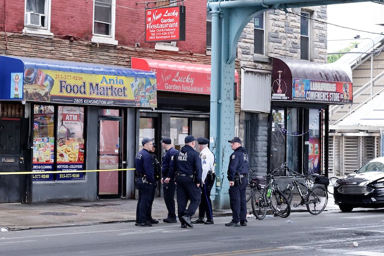 Philadelphia police officers stand guard along the 2800 block of Kensington Avenue, near the 2800 block of D Street after police said a sergeant shot a man in Kensington on Saturday, May 23, 2026.