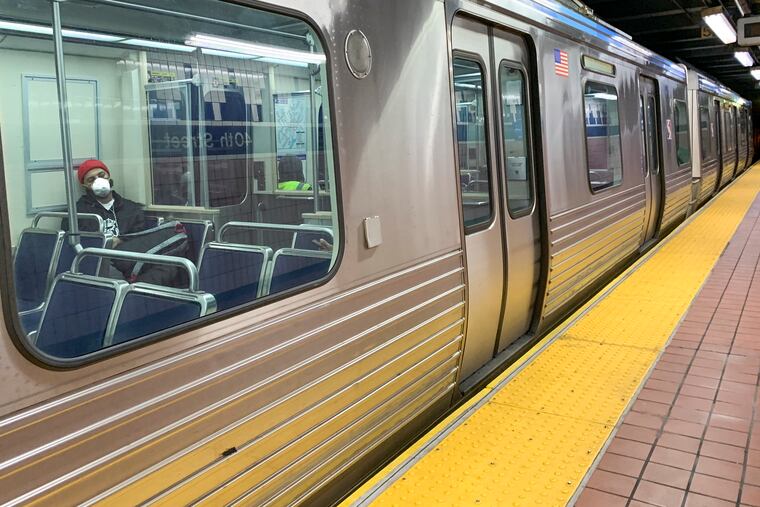 A passenger wears a mask on a SEPTA Market-Frankford Line train going westbound on Friday, March 27, 2020.