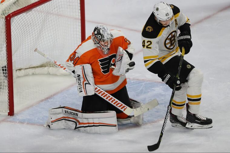 Flyer goalie Petr Mrazek, left, uses his glove to stop thee deflection shot of Bosotn’s #42, David Backes, right, during a Bruin’s power play in the second period of Sunday’s game on April 1, 2018 at the Wells Fargo Center. MICHAEL BRYANT / Staff Photographer