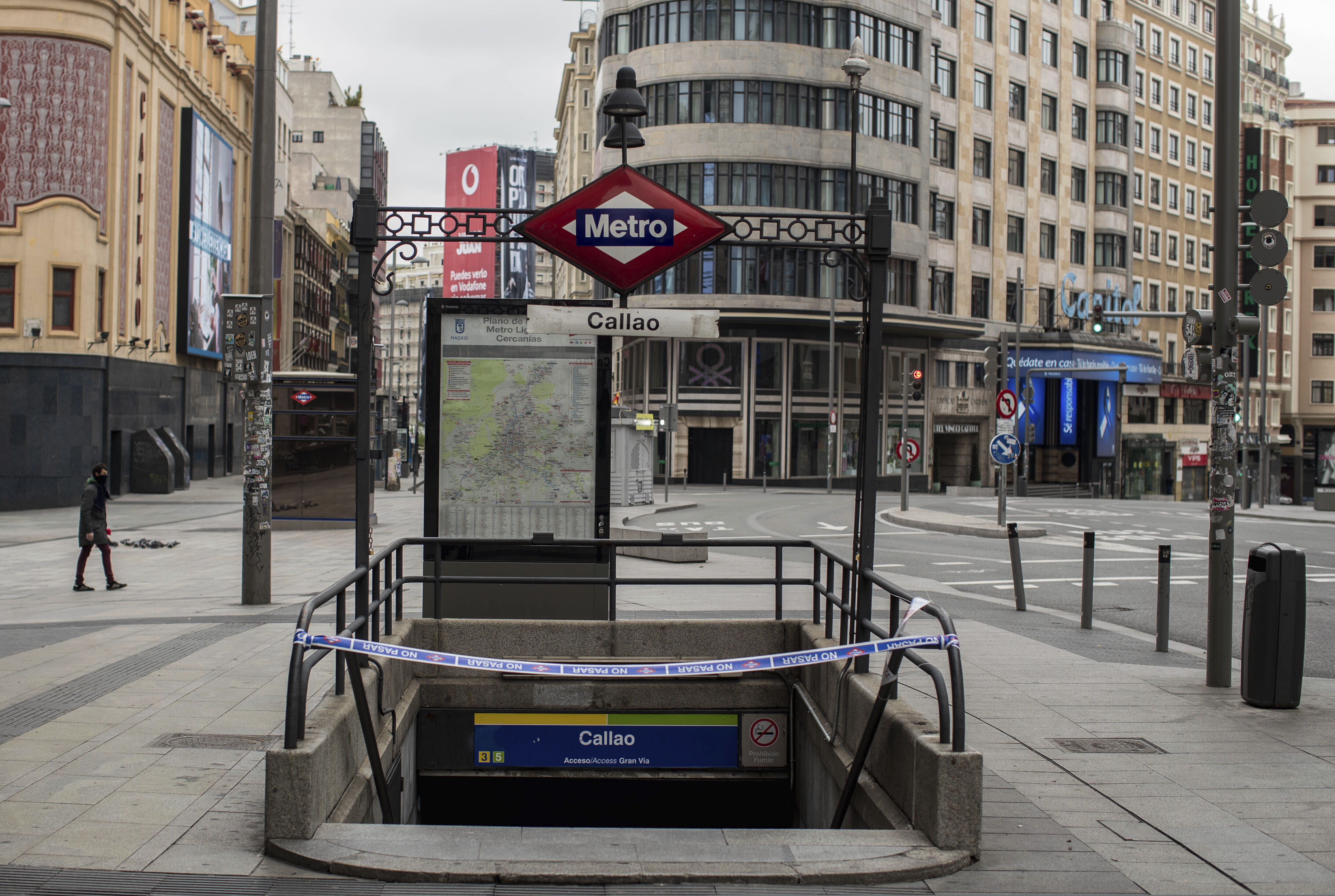 In this April 14 photo, a man walks past a closed subway station during the lockdown to combat the spread of coronavirus in downtown Madrid.