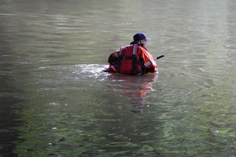 An unidentified officer from the Philadelphia police marine unit searches the Pennypack Creek near the I-95 overpass for the missing teen on August 14, 2013.
( DAVID MAIALETTI / Staff Photographer )