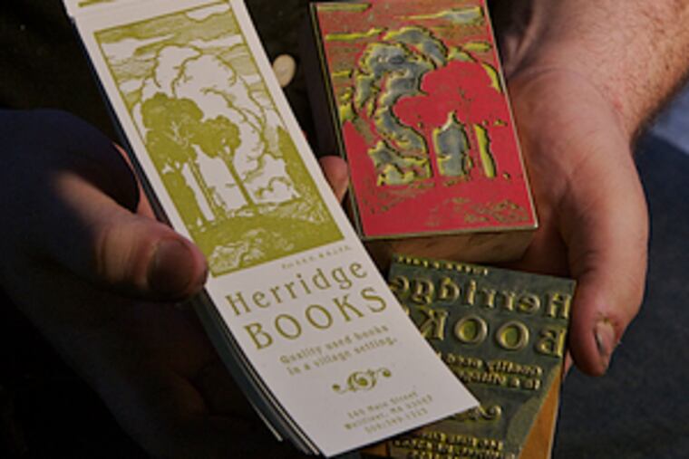 Ryan Howell of Mad Maude Press holds a sample of a finished bookmark and the blocks used for inking on his 100-year-old press. He hopes to live entirely off the love of letterpress.