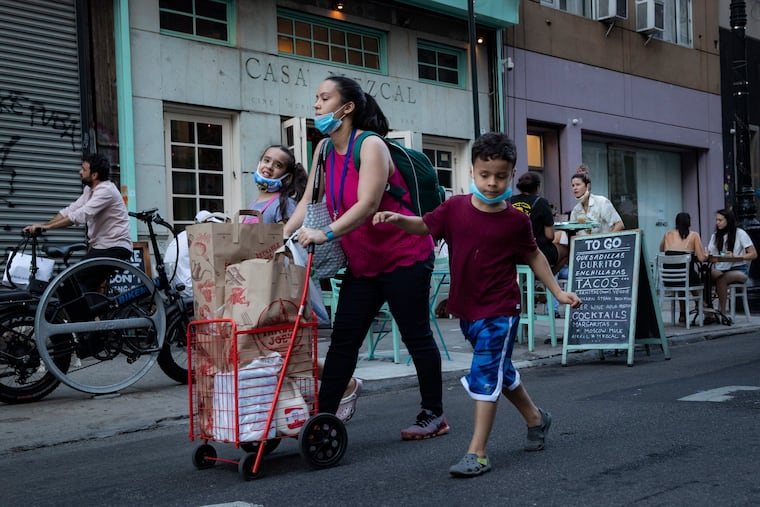Pedestrians walk past customers dining outside Casa Mezcal in New York.