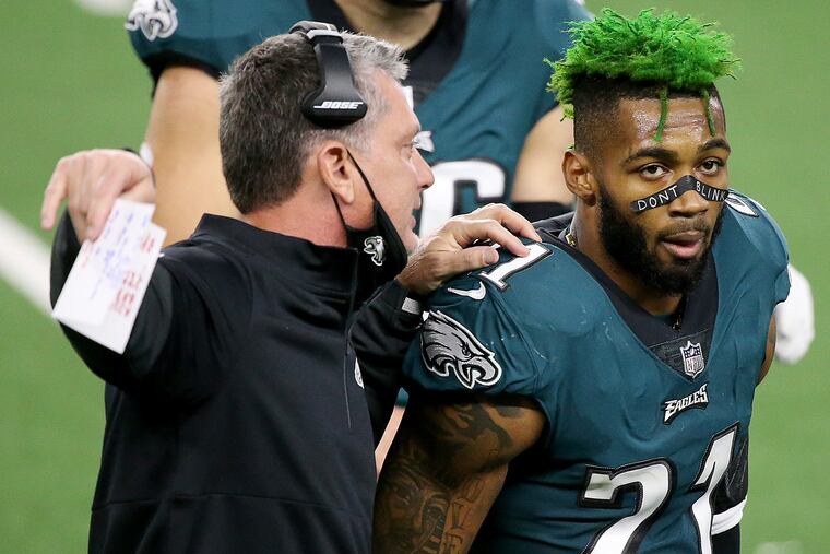 The Eagles placed Jalen Mills on the reserve/COVID-19 list Thursday. Here, Mills confers with defensive coordinator Jim Schwartz at the end of Sunday's loss at Dallas.