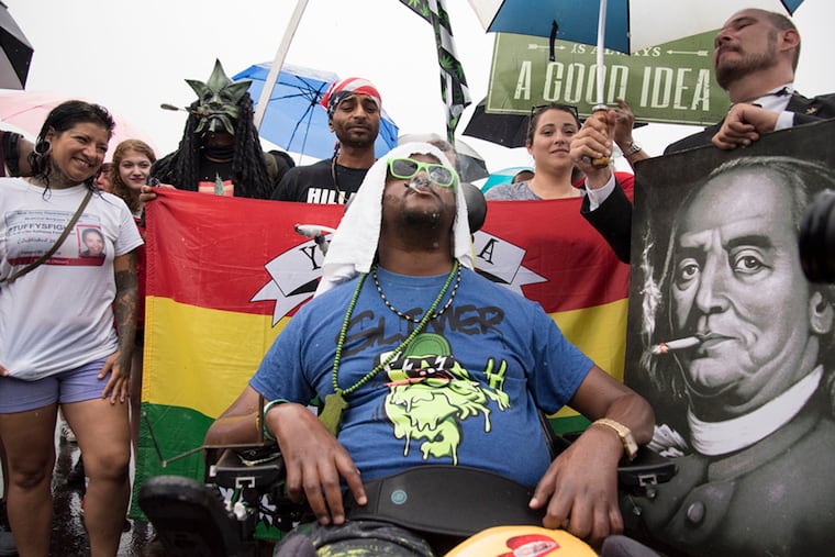 A protester participates in the protest for the legalization of marijuana outside the Wells Fargo Center on the same day as the final night of the DNC in 2016.
