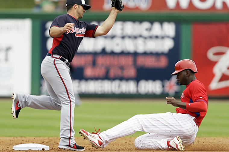 Domonic Brown, right, steals second base ahead of the tag by Braves second baseman Dan Uggla during the second inning on Wednesday, March 5, 2014, in Clearwater, Fla. (Charlie Neibergall/AP)