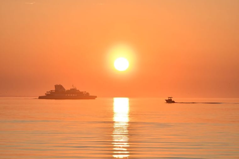 The Cape May-Lewes Ferry and a smaller boat at sunset in the bay off Lewes in May.