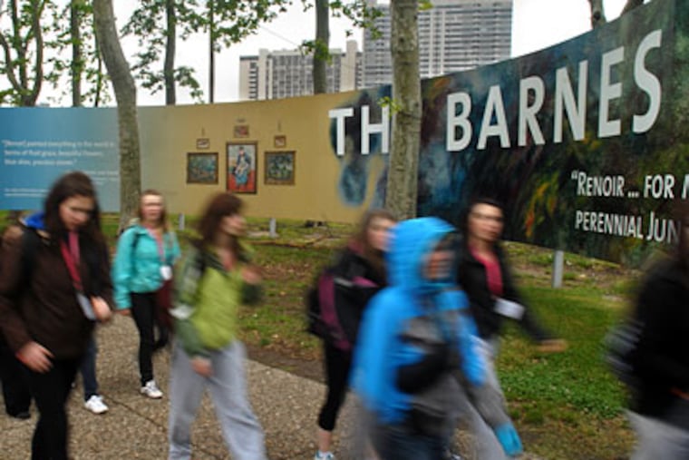 Passersby create an impressionist blur as they walk past the construction site for the Barnes Foundation on the Parkway. ( Tom Gralish / Staff Photographer )