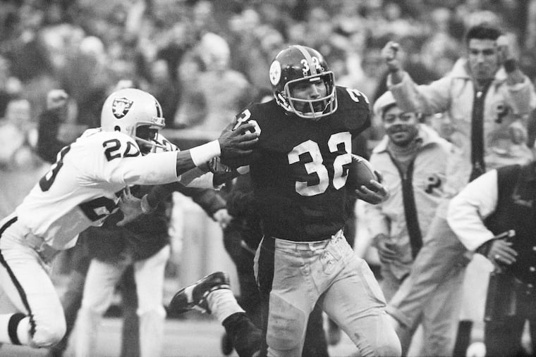 The Pittsburgh Steelers' Franco Harris (32) eluded a tackle by the Oakland Raiders' Jimmy Warren as he ran 42 yards for a touchdown after catching a deflected pass during an AFC Divisional football playoff game in Pittsburgh on Dec. 23, 1972.