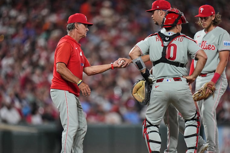 Phillies interim manager Don Mattingly (left) takes the ball from pitcher Orion Kerkering during a pitching substitution in the seventh inning.