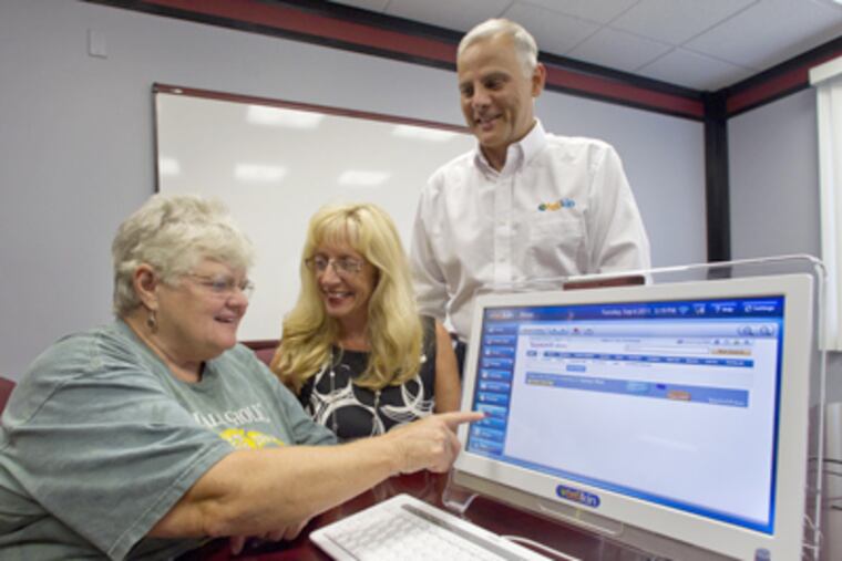 Fred Allegrezza and his wife, Nancy, watch as Carol Ann Davis (left) of North Wales operates the Telikin touch screen. (David M Warren / Staff Photographer)