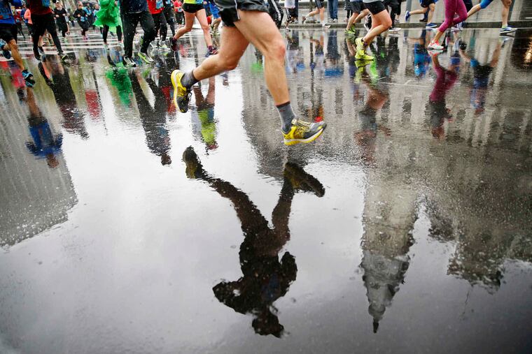 City Hall is reflected along with the runners on the rain-soaked street during the 2016 Independence Blue Cross Broad Street Run. Similarly rainy weather is expected for the 2019 edition of the race.