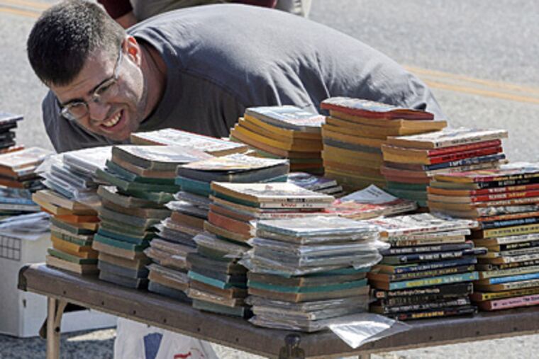 With nine titles already in the bag, Rich Wiest, 32, of Williamstown, peruses more at the sixth annual Collingswood Book Festival. Organizers expected a crowd of about 6,000. (Akira Suwa / Staff Photographer)