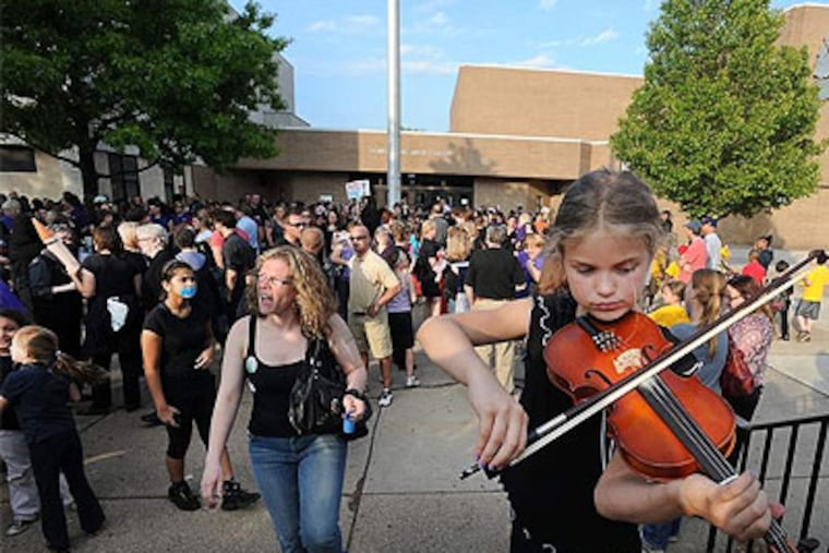 Ava Cooley, 9, plays her violin to a crowd of more than 500 protesters outside Upper Darby High School before a school board meeting. Cuts are expected to be made to the arts, foreign language, music, technology, and other programs. (Sharon Gekoski-Kimmel / Staff Photographer)