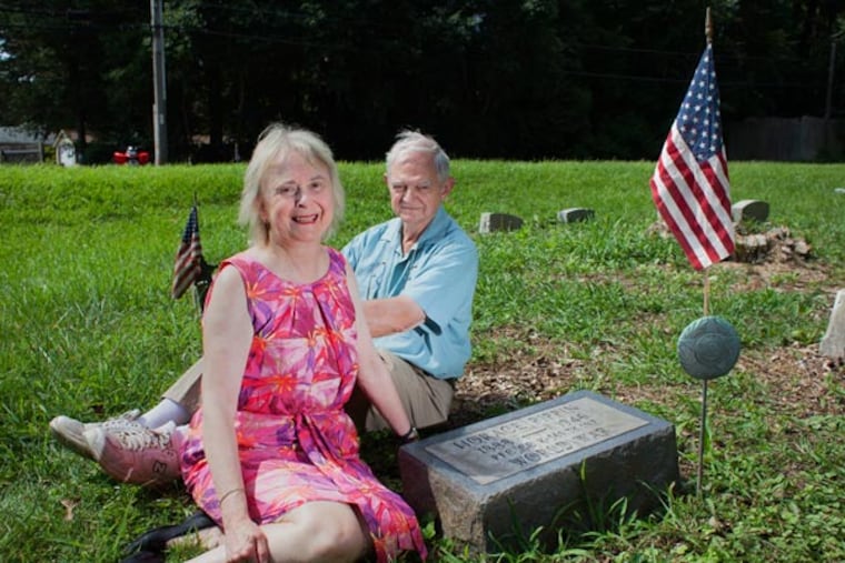 Christina and Dwight McCawley at the gravesite of the artist Horace Pippin. When the couple saw that the grave had been neglected, they took it upon themselves to clean it up.
