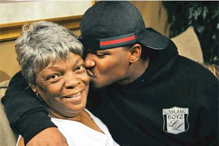 Curtis Brinkley, the city leagues’ all-time rushing leader, who was shot in July, kisses his grandmother, Margie Cason. (Sarah J. Glover / Staff Photographer)