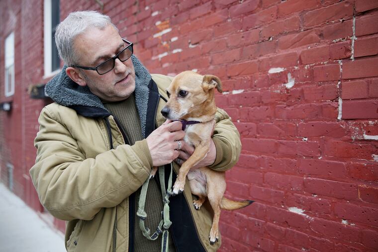 Ernie Anziano with his dog Wilbur outside his South Philadelphia home. Anziano was hoping to pay Wilbur's veterinary bills with his tax refund, but his refund this year will be less than he was hoping for.