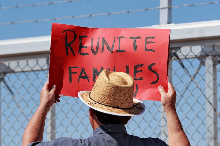 In this June 21, 2018 file photo, a protester holds a sign outside a closed gate at the Port of Entry facility in Fabens, Texas, where tent shelters were being used to house separated family members.