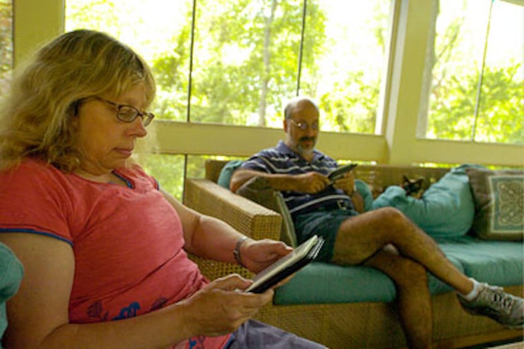 Faith Paulsen and her husband Barton Sacks read their Kindles in their East Norrinton home. (Ron Tarver / Staff Photographer)