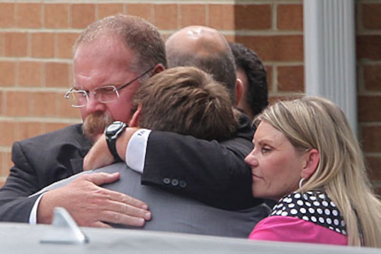 Andy Reid hugs his son Britt and wife Tammy following the funeral service for Garrett Reid on Tuesday. (Michael Bryant/Staff Photographer)