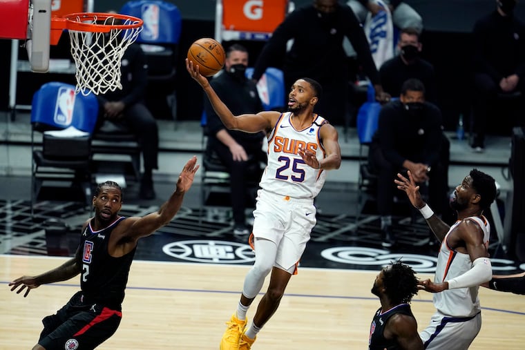 Suns forward Mikal Bridges (center) scores over Clippers forward Kawhi Leonard.