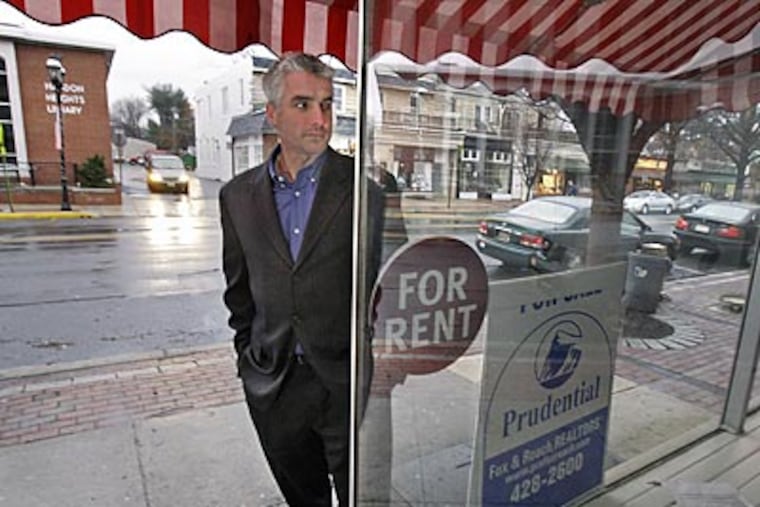 Haddon Heights Mayor Scott Alexander looks into a vacant storefront on Station Avenue. He hopes to lure new businesses downtown. (Elizabeth Robertson/Staff Photographer)