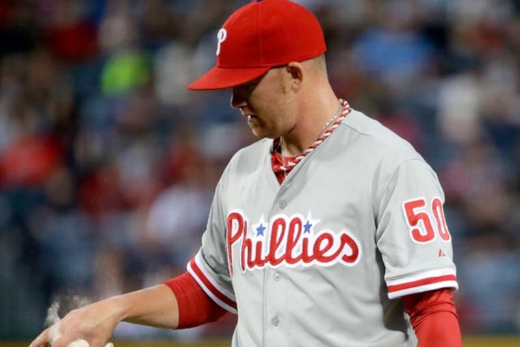 Tyler Cloyd chalks his hand after giving up a single to Atlanta Braves' Evan Gattis allowing Freddie Freeman to score in the first inning of a baseball game, Thursday, Sept. 26, 2013, in Atlanta. (David Goldman/AP)