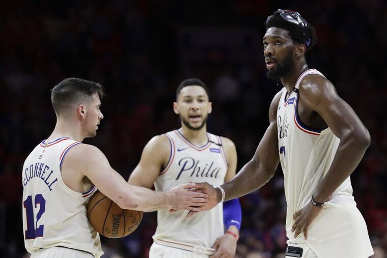 Sixers guard T.J. McConnell gives five to teammate center Joel Embiid with guard Ben Simmons late in the fourth quarter against the Boston Celtics in game four of the Eastern Conference semifinals on Monday, May 7, 2018 in Philadelphia. YONG KIM / Staff Photographer