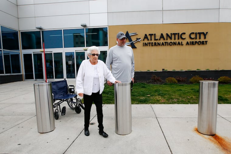 Betty Scottino, 92, leaves the Atlantic City International Airport with her grandson Ed Bober of Hammonton on Sunday after arriving on a near-empty flight from Florida, seemingly unfazed by the coronavirus pandemic and a related travel advisory.