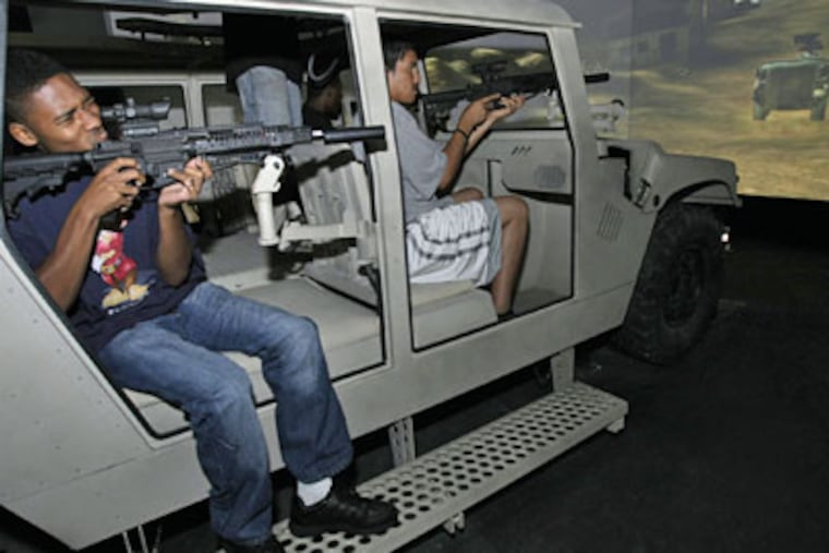 Bryon Clements (left), who is going into the Army, and Edwin Guzman, handle assault weapons in the "Armored Humvee" simulator (Allejandro A. Alvarez/Daily News)