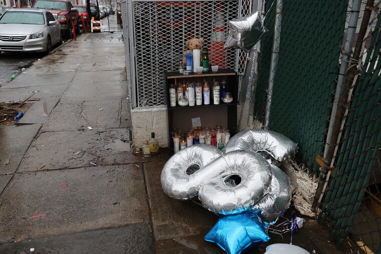 A makeshift memorial at North Mascher and West Cambria Streets in Philadelphia's Fairhill section Sunday, where a police officer was shot Friday night and Alexander Spencer, the man police originally said shot him, was killed by the officer's partner. A video of the shooting raises questions over who shot the officer.