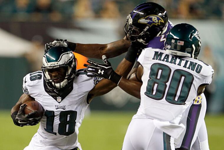 Rasheed Bailey (left) runs with the ball as teammate Martino blocks Baltimore Raven Brynden Trawick.