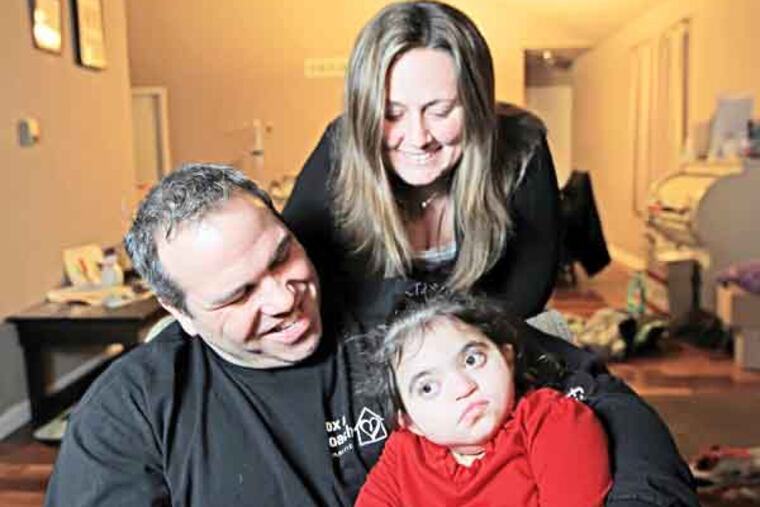 Joe Rivera and his wife Chrissy Rivera hold on tight to their daughter Amelia Rivera, 3 ( Michael Bryant / Staff photographer )