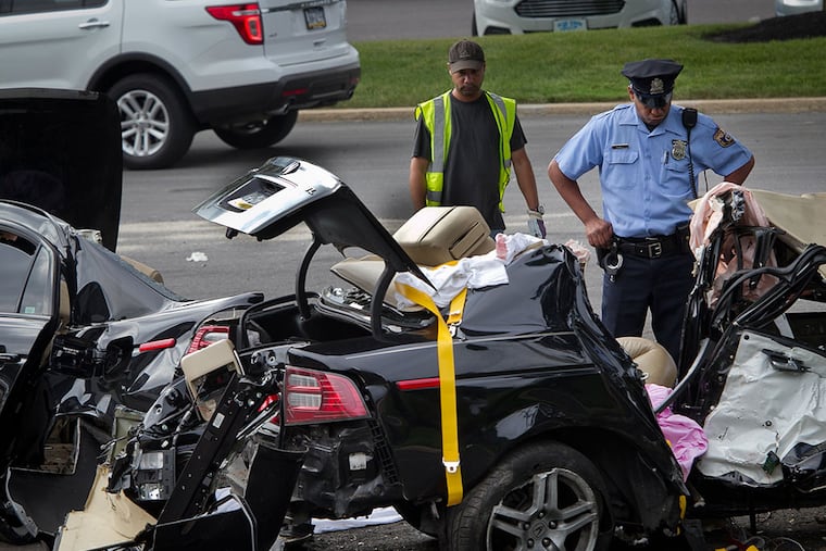 A Philadelphia police officer looks over an Acura destroyed Wednesday night in a fatal crash on Sandmeyer Lane just east of Red Lion Road in Northeast Philadelphia. The car was split in half after hitting a tree next to a driveway. ALEJANDRO A. ALVAREZ / Staff Photographer