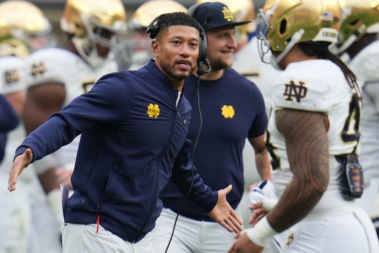 Notre Dame head coach Marcus Freeman, left, greets players as they return to the sideline during the second half of an NCAA college football game against Pittsburgh in Pittsburgh, Saturday, Nov. 15, 2025. (AP Photo/Gene J. Puskar)
