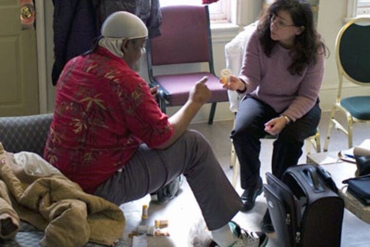 Nurse practitioner Kathleen Jackson advises client Paul at Camden's Victory Outreach House. The program is run by the Camden Coalition of Healthcare Providers. (Matt Rainey / Kaiser Health News)