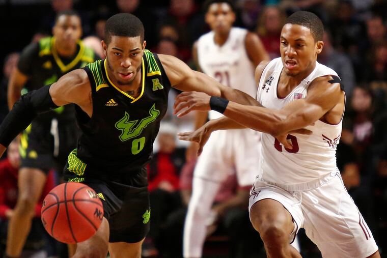 Temple guard Nate Pierre-Louis (right) eyes the ball after knocking it loose from South Florida guard David Collins in the first half.