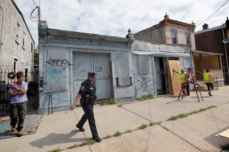 Camden Department of Public Work and police detectives board up the garage belonging to a home on 1137 Liberty Street in Camden, New Jersey where the body of Curtis Jenkins III, was found dead. Camden police continue investigating the area on Wednesday, June 3, 2019.
