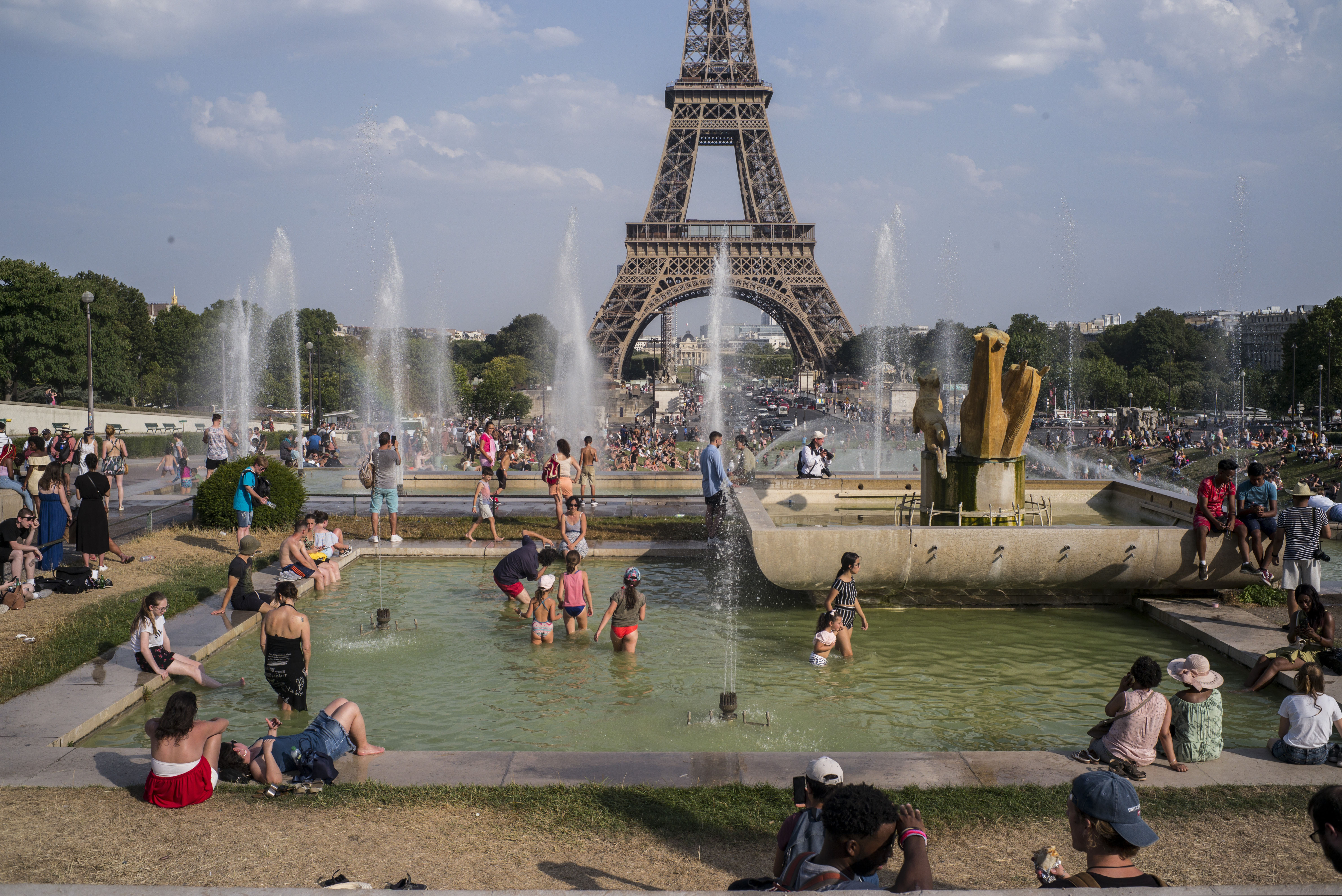 People enjoy the sun and the fountains of the Trocadero gardens in Paris, Thursday July 25, 2019, when a new all-time high temperature of 42.6 degrees Celsius (108.7 F) hit the French capital.