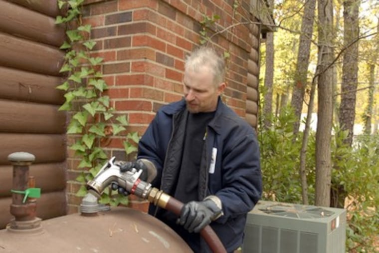 John Wallace, a heating oil deliveryman for Harriett's Oil Service in Medford NJ, fills a tank in Medford Lakes, NJ. (Ron Tarver/ Staff Photographer)