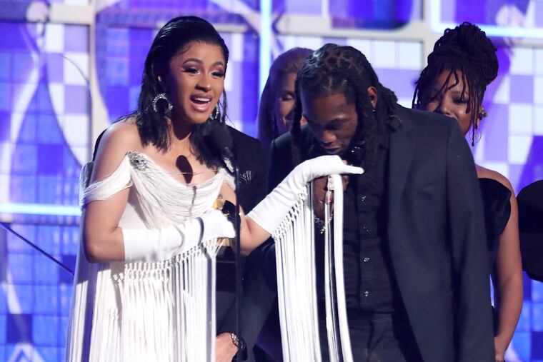 FILE - This Feb. 10, 2019 file photo shows Cardi B, left, accepting the award for best rap album for "Invasion of Privacy" as Offset kisses her hand at the 61st annual Grammy Awards in Los Angeles. The rapper has come under fire this week for what she says is a three-year-old video in which she claims she drugged men and robbed them. In the clip posted to Instagram Live, an emotional Cardi B explains in order to make it in the music industry _ and in life _ she had to do some things she is not proud of. (Photo by Matt Sayles/Invision/AP, File)
