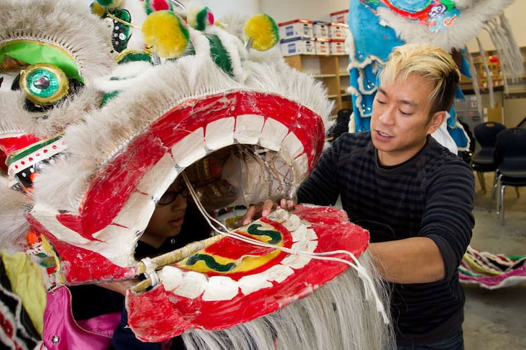 Kenneth Mui helps a student learn a traditional lion dance at Folk Arts charter. (ALEJANDRO A. ALVAREZ / STAFF PHOTOGRAPHER)