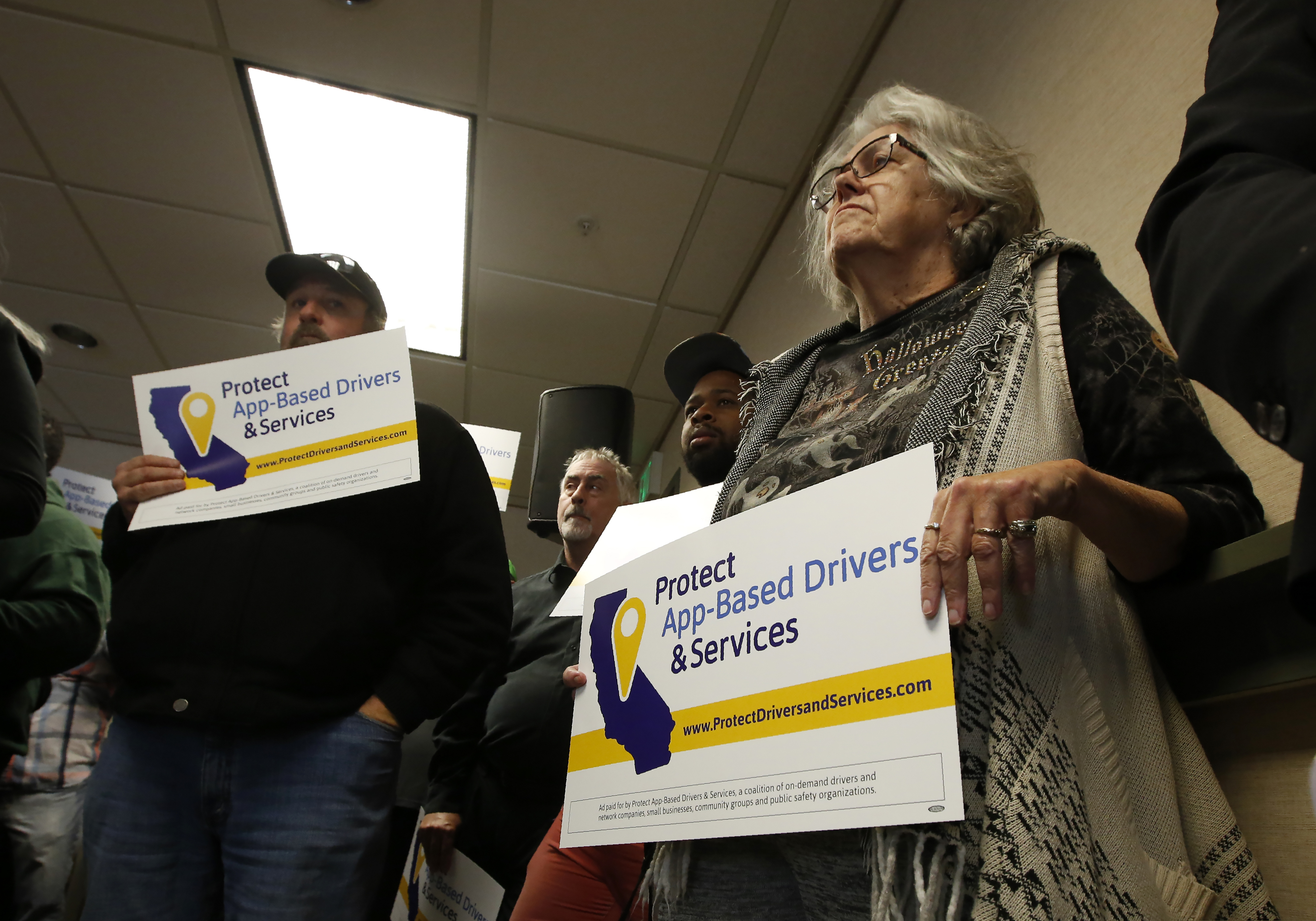 Carla Shrive, right, who drives for various gig into companies, joined other drivers to support a proposed ballot initiative challenging a recently signed California law that makes it harder for companies to label workers as independent contractors, in Sacramento, Calif., Oct. 29, 2019. A group called Protect App-Based Drivers and Services announced Tuesday that it will push a ballot initiative guaranteeing that drivers remain independent contractors but also receive a minimum wage and money for health insurance, echoing a nationwide debate on compensation for freelance and part-time workers.