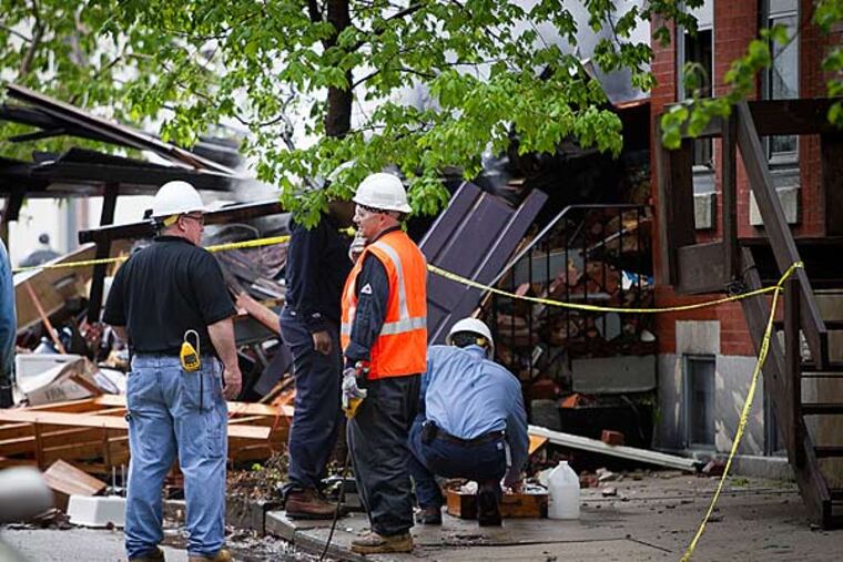 Philadelphia fire, police and a PGW crew work along the 2300 block of Naudain, investigating and cleaning up after an early morning fire and explosion on Thursday morning May 1, 2014.