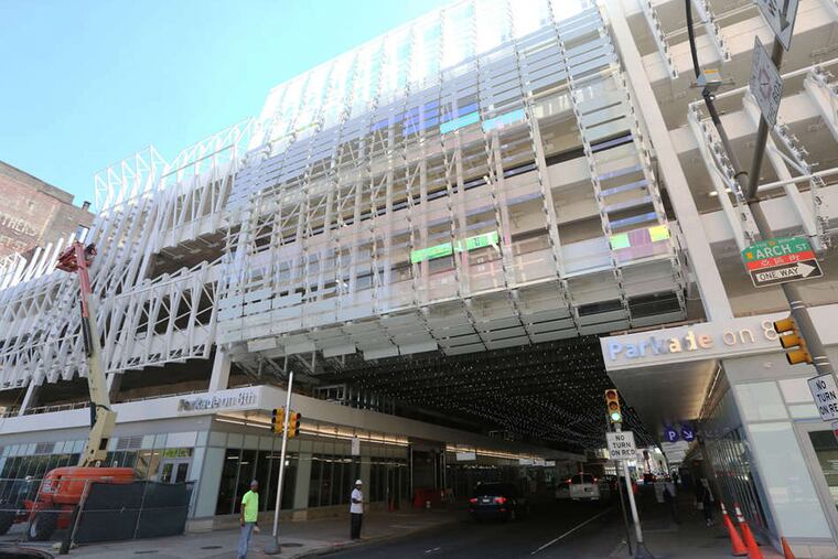 The northern facade of the Parkade over Eighth Street has small glass panes - colored, frosted, and transparent - glittering or changing color while set against snow-white paint.
