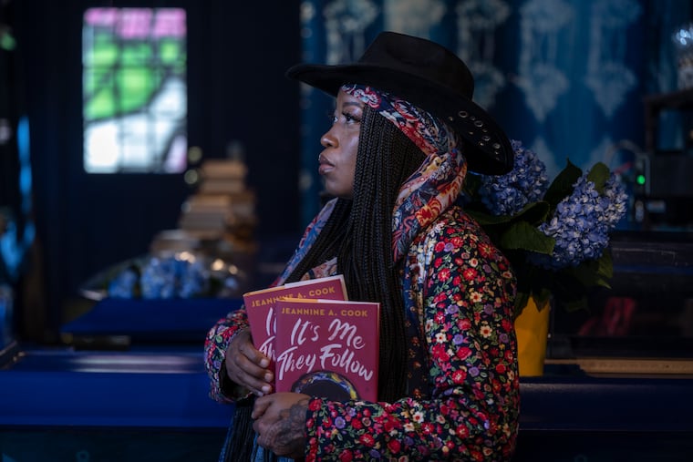 Author Jeannine Cook poses with her book on Monday, Sept. 15, 2025, at the newly refurbished Harriett's Bookshop in Philadelphia.